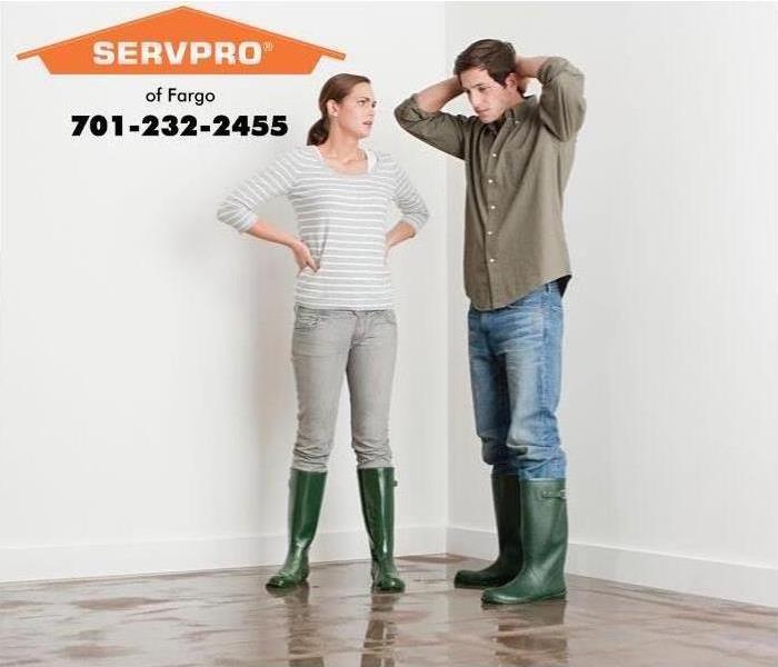 couple standing with rain boots and standing water 
