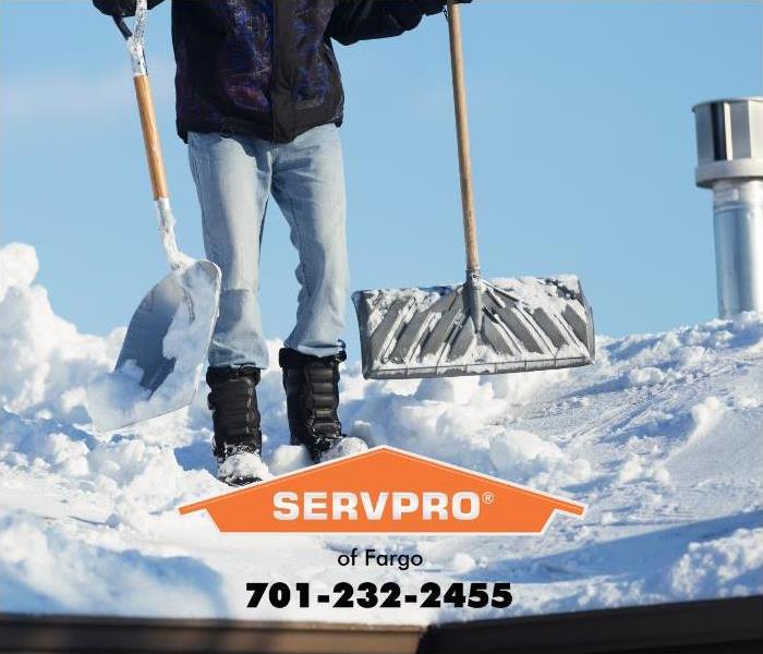 A man removing snow from a snow-laden roof is shown.